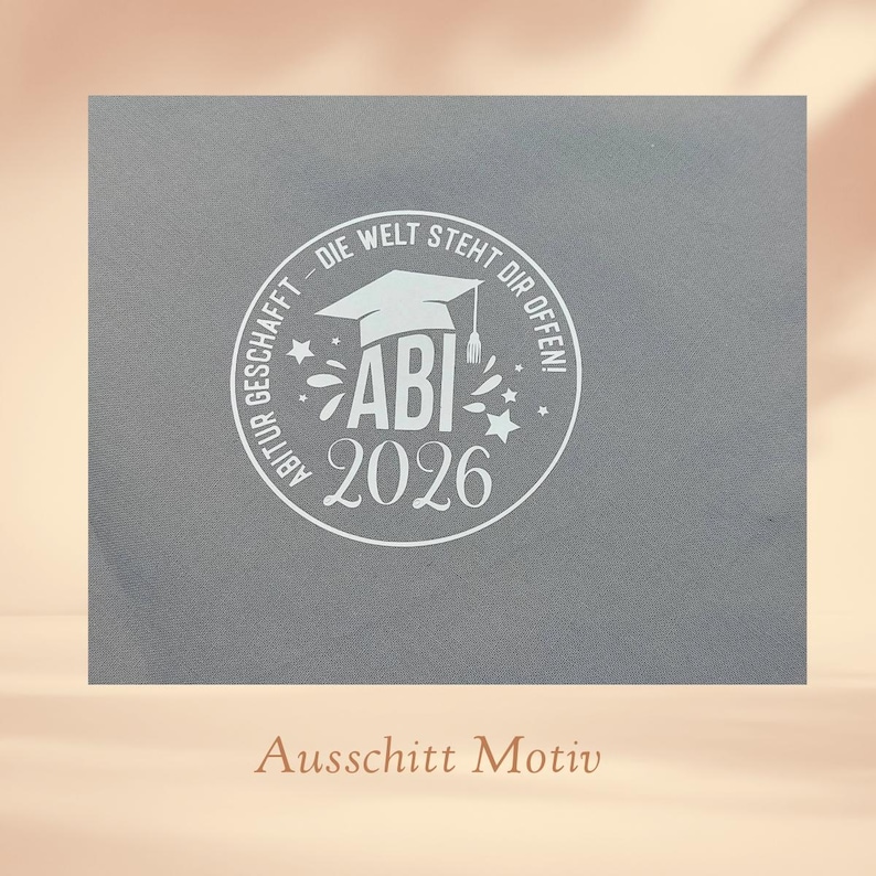 K&ouml;nnte beinhalten: Eine graue Abschlusskarte mit einem wei&szlig;en kreisf&ouml;rmigen Design. Das Design enth&auml;lt eine Abschlusskappe, das Wort "ABI" und das Jahr "2026". Der Text "DIE WELT STEHT DIR OFFEN!" ist ebenfalls enthalten.