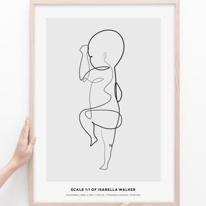 May include: A black and white line drawing of a baby in a minimalist style. The drawing is framed in a light wood frame. The text below the drawing reads "SCALE 1:1 OF ISABELLA WALKER CALIFORNIA/APRIL 6, 2019/7:30 P.M./7 POUNDS 4 OUNCES/19 INCHES"