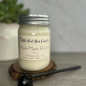 Puede incluir: Una vela de 340 gramos en un tarro de vidrio con tapa plateada. La vela est&aacute; etiquetada como "Little Red Hen Candles" y "Apple Maple Bourbon". La vela est&aacute; hecha a mano en Warsaw, Indiana, y hecha con cera de soja totalmente natural.