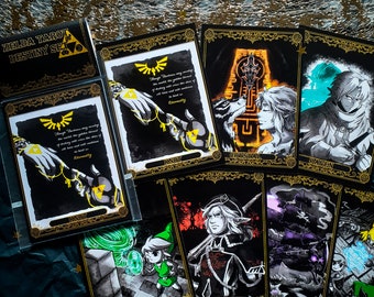 May include: A Zelda Tarot Destiny Set featuring black cards with gold trim and illustrations. The cards include images of characters and symbols from the game, with text and the Triforce symbol. The box is black with gold text.