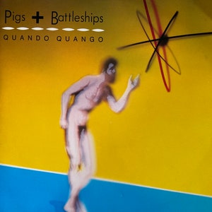 May include: A yellow and blue background with a nude figure in the foreground. The figure is facing right and looking up at a red and black abstract design in the upper right corner. The text "Pigs + Battleships" and "QUANDO QUANGO" is at the top of the image.