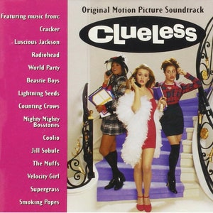 May include: A pink and white CD case with the title "Clueless" in black text. The case features a photo of three women on a staircase. The women are wearing colorful outfits and holding cell phones. The case lists the artists featured on the soundtrack, including Cracker, Luscious Jackson, Radiohead, and Coolio.