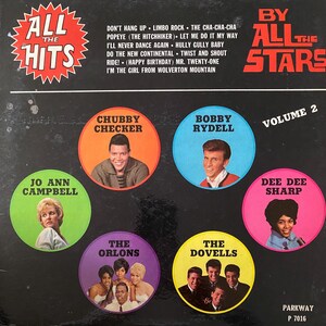 May include: Vintage vinyl record album cover titled "All The Hits By All The Stars Volume 2." Features portraits of Chubby Checker, Bobby Rydell, Dee Dee Sharp, Jo Ann Campbell, The Orlons, and The Dovells. Black background with red, orange, green, blue, pink, purple, and yellow circles.