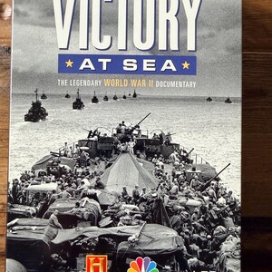 May include: A DVD case for "Victory at Sea," a World War II documentary. The cover features a black and white image of a warship filled with soldiers, with the title in large white letters. The History Channel and NBC News logos are visible.