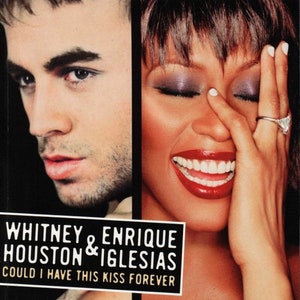 May include: A close-up image of a music album cover featuring Whitney Houston and Enrique Iglesias. The album title is "Could I Have This Kiss Forever".