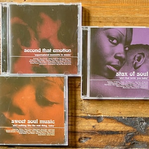 May include: Three CDs with album art. The top CD is titled "second that emotion" with the subtitle "supernatural moments in music." The bottom CD is titled "sweet soul music" with the subtitle "ain't nothing like the real thing, baby." The third CD is titled "stax of soul" with the subtitle "ain't that lovin' you baby."
