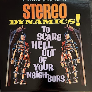 May include: A vintage record album cover with a black background and the text "STEREO DYNAMICS! TO SCARE HELL OUT OF YOUR NEIGHBORS". The album cover features two skeletons hanging from a wooden structure.