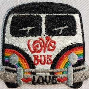 May include: Embroidered patch featuring a black and white bus with a rainbow design. The text "Love Bus" is embroidered in red. The word "Love" is embroidered at the bottom with red hearts.
