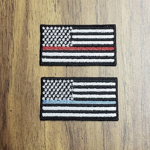 May include: Two embroidered American flag patches. The top patch has a red stripe across the middle, representing firefighters. The bottom patch has a blue stripe across the middle, representing law enforcement.
