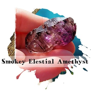 May include: A raw, smoky elestial amethyst crystal with deep purple and brown hues. The crystal is held in a hand, showcasing its natural, textured surface. The text "Smokey Elestial Amethyst" is displayed below the crystal.