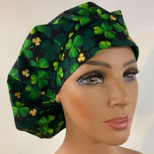 May include: A black scrub hat with a green shamrock print and gold glitter accents.