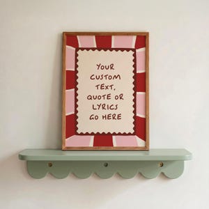 May include: A rectangular wooden frame containing a print with a cream-coloured centre featuring a scalloped border and the text "YOUR CUSTOM TEXT, QUOTE OR LYRICS GO HERE" in dark brown, surrounded by a red and pink sunburst pattern.