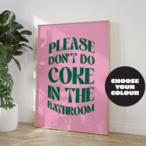 May include: A pink poster with the text "PLEASE DON'T DO CORE IN THE BATHROOM" in green letters. The poster is framed in gold and has a black circle with the text "CHOOSE YOUR COLOUR" in white letters.