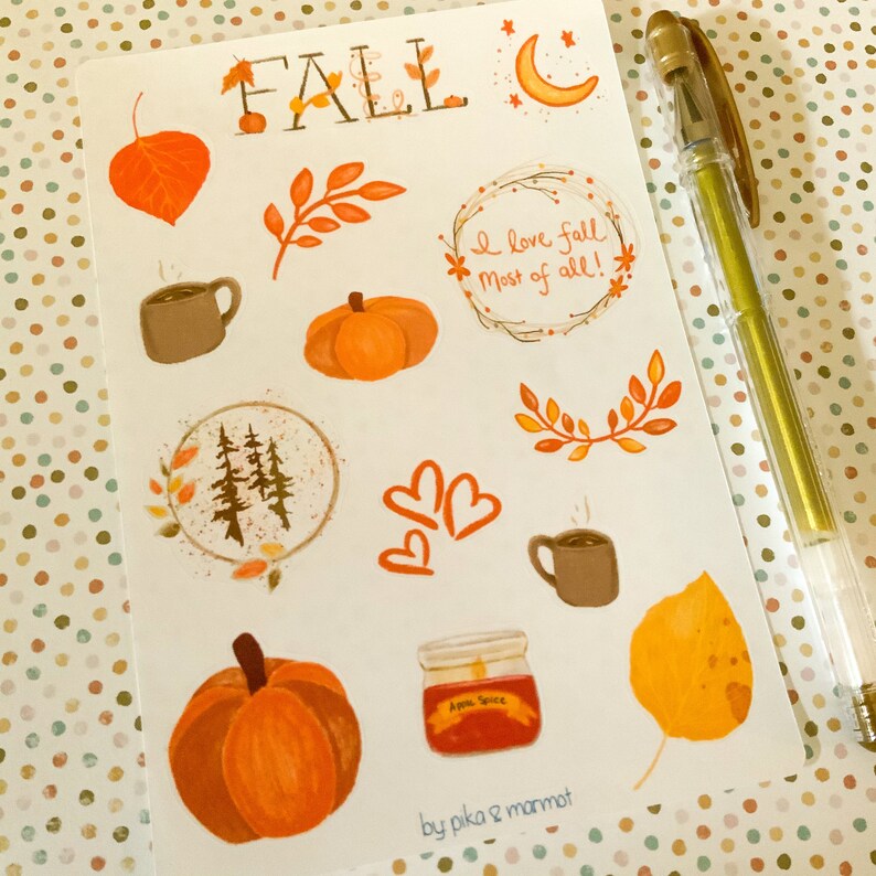 May include: A sheet of stickers with a fall theme. The stickers feature images of pumpkins, leaves, coffee mugs, a jar of apple spice, and a crescent moon. The text "FALL" and "I love fall most of all!" are also included on the sheet.
