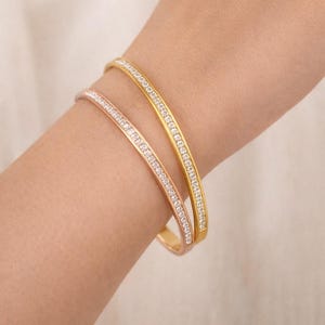 May include: A white ceramic mug with a black handle and the text "But First, Coffee" in a bold, black font. The mug is sitting on a wooden surface. The mug is 4 inches tall.