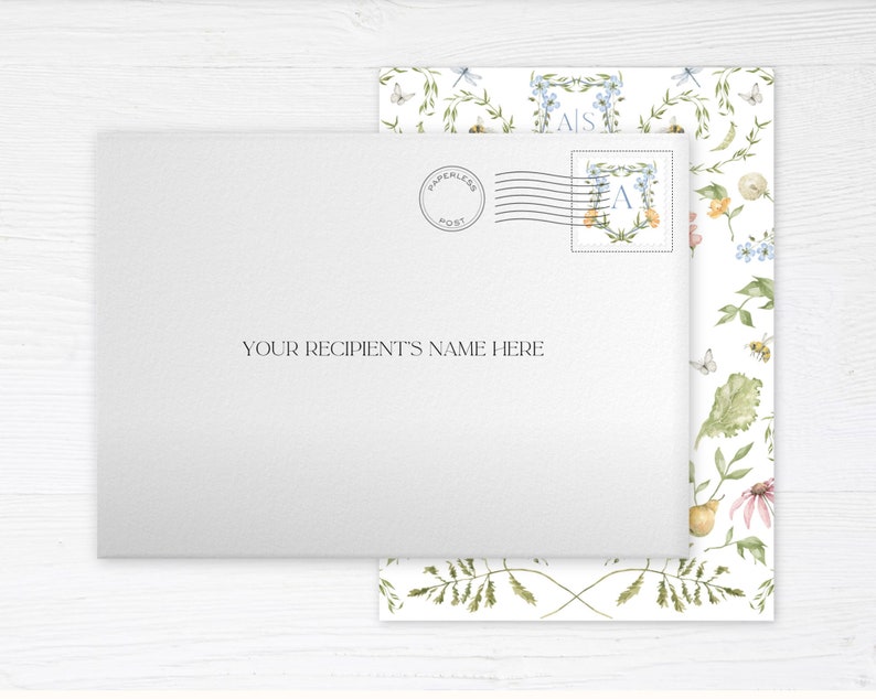 May include: A white envelope with a floral pattern on the back. The envelope has a "Paperless Post" stamp and a monogrammed stamp with the letter "A". The text "YOUR RECIPIENT'S NAME HERE" is printed on the front of the envelope.
