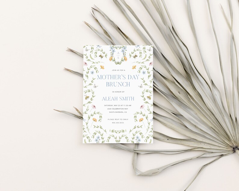 Pu&ograve; includere: Un invito bianco con un bordo floreale e il testo "Mother's Day Brunch" in lettere blu. L'invito &egrave; per un brunch in onore di Aleah Smith sabato 23 maggio alle 11:30 al 605 Celebration Way, Santa Barbara, CA. Il numero di telefono 805.385.3415 &egrave; incluso.