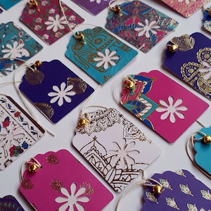 Étiquettes cadeaux faites main de luxe aux couleurs riches, belles couleurs avec des motifs en feuille d'or et une cloche