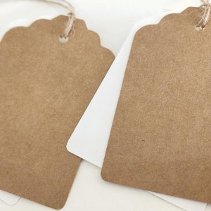 May include: Two brown paper gift tags with scalloped edges and a hole punched at the top. The tags are tied with twine.