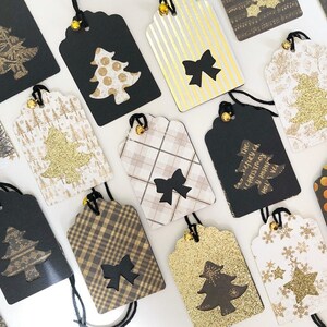 Pu&ograve; includere: Una collezione di 14 etichette regalo di Natale con vari design. Le etichette sono nere, dorate, bianche e marroni con diversi motivi, tra cui scozzese, pois, fiocchi di neve e glitter. Alcune etichette hanno una forma di albero di Natale ritagliata con un albero di glitter dorato all'interno. Alcune etichette hanno il testo "The very merry Christmas & Happy New Year!" stampato su di esse.