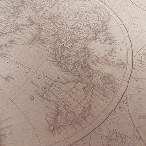 May include: A vintage world map printed on paper with a brown background. The map shows the continents of Asia, Australia, and Antarctica. The map is labeled with the names of countries and oceans.