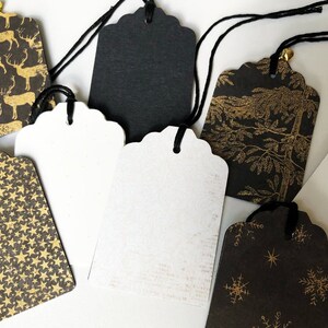 Pu&ograve; includere: Assortimento di etichette regalo nere e bianche con disegni in foglia d'oro. Le etichette presentano vari motivi, tra cui renne, stelle, fiocchi di neve e alberi. Ogni etichetta &egrave; dotata di uno spago nero.