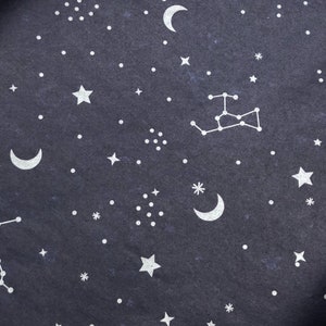May include: A dark blue fabric with a white constellation pattern. The pattern includes stars, crescent moons, and a constellation of stars.