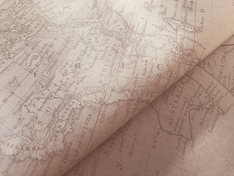 May include: A close-up of a vintage map of the world, with the continent of Africa highlighted in brown. The map is folded in half, revealing a portion of Australia on the bottom right.