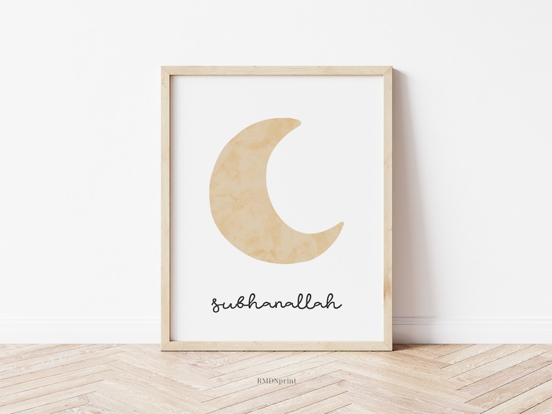 May include: A framed art print featuring a beige crescent moon on a white background. The word "subhanallah" is written in a cursive font below the moon. The frame is made of light-colored wood.