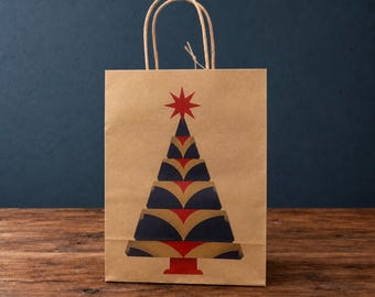 Bolsa de regalo con diseño de árbol de Navidad Art Déco en rojo y azul, impresa en papel kraft natural con etiqueta de regalo.