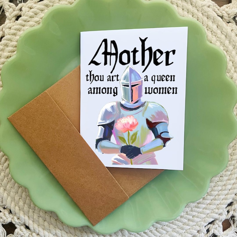 May include: A white card with a knight in armor holding a pink flower. The card reads "Mother thou art a queen among women".