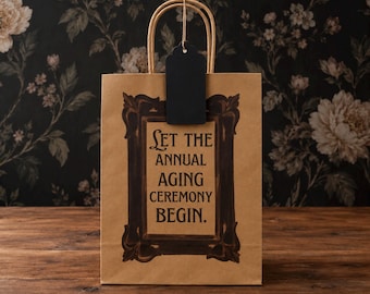 Bolsa de regalo de cumpleaños gótica sarcástica en papel kraft natural con etiqueta de regalo.