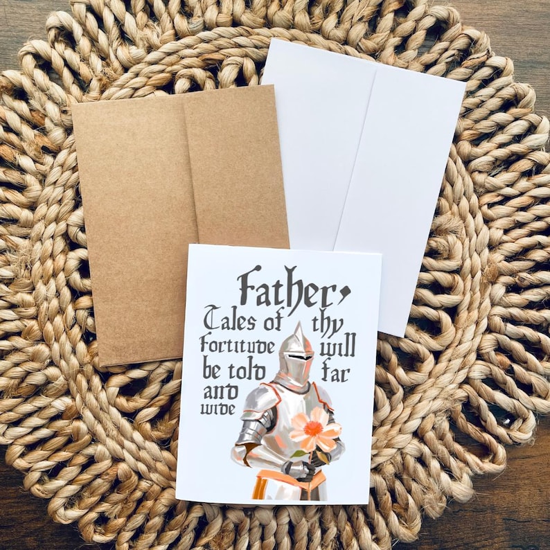 May include: A white card featuring a knight in silver armour holding a pink flower. The card reads "Father, Tales of thy fortitude will be told far and wide."