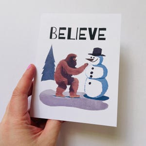 Cartão de Natal do Pé Grande construindo um boneco de neve “Believe”, Cartão de férias do Pé Grande, Cartão de Natal do Sasquatch, Presente de Natal do Sasquatch, Presente do Pé Grande