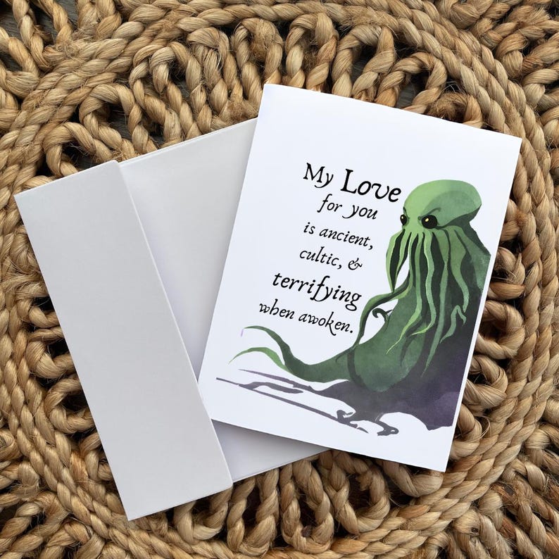 May include: Greeting card with a white envelope. The card features the text "My Love for you is ancient, cultic, & terrifying when awoken." and a green tentacled creature illustration.
