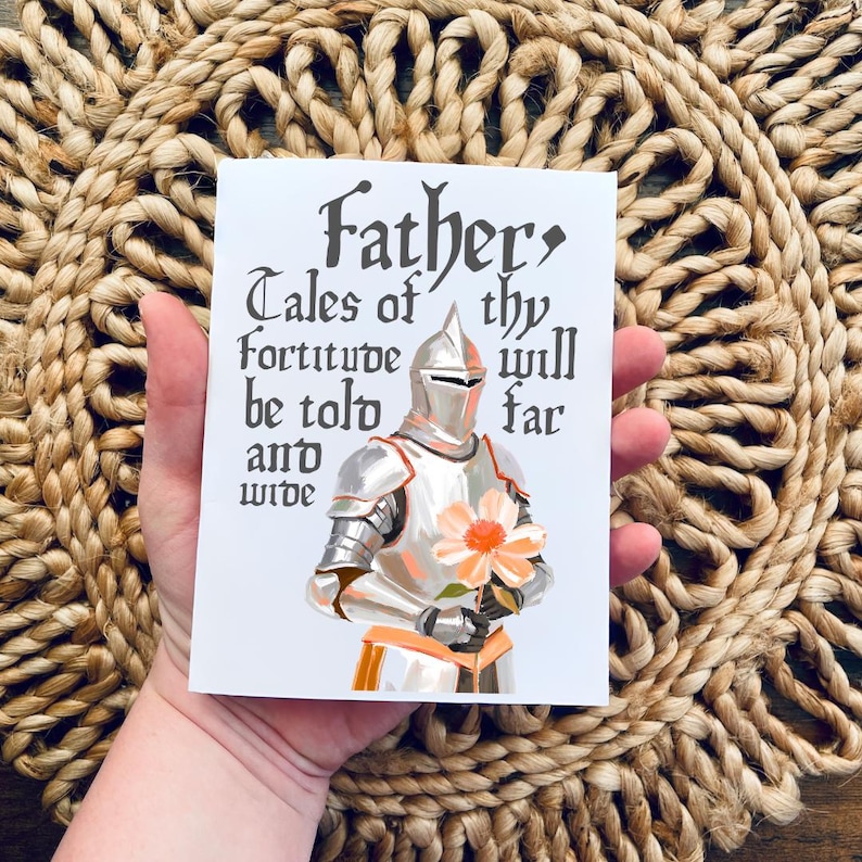 May include: A white card with a knight in silver armour holding a pink flower. The card has the text "Father, Tales of thy fortitude will be told far and wide."