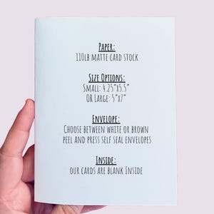 May include: A folded white card with text detailing paper type, size options (4.25"x5.5" or 5"x7"), envelope choices, and that the inside is blank. The card is held by a person's hand.