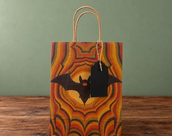 Bolsa de regalo de Halloween con diseño psicodélico de murciélago caleidoscópico en papel kraft natural con etiqueta de regalo.