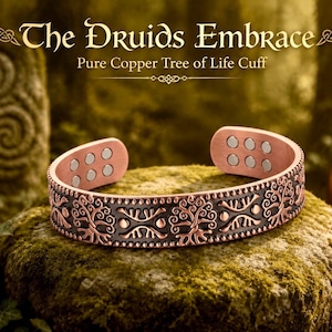 May include: A copper cuff bracelet featuring a repeating Tree of Life motif with dark recessed detailing and beaded edges. The interior of the open-ended band displays six circular silver-toned magnets. Text reads: The Druids Embrace Pure Copper Tree of Life Cuff.