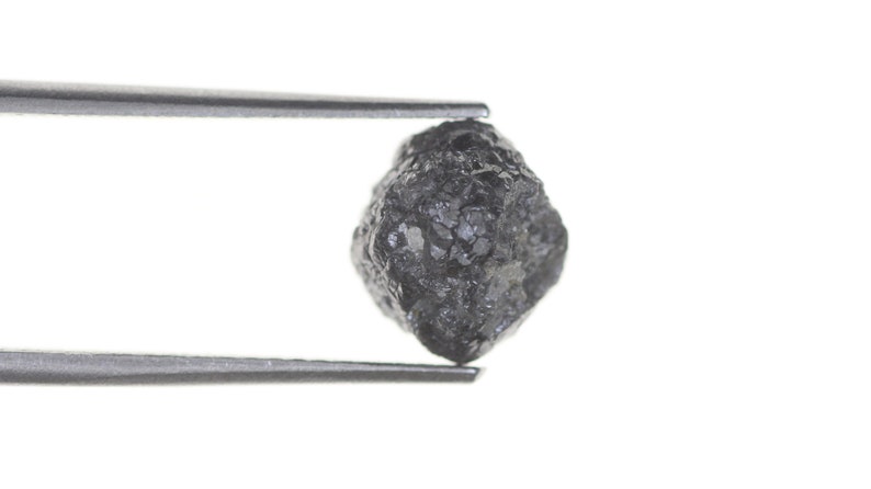 Pode incluir: Uma caneca de cer&acirc;mica branca com uma al&ccedil;a preta e o texto "But First, Coffee" em negrito preto. A caneca est&aacute; sobre uma superf&iacute;cie de madeira. A caneca tem 10 cm de altura.