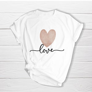 K&ouml;nnte beinhalten: Wei&szlig;es T-Shirt mit einem ros&eacute;goldenen Herzen und dem Wort "love" in schwarzer Schrift.