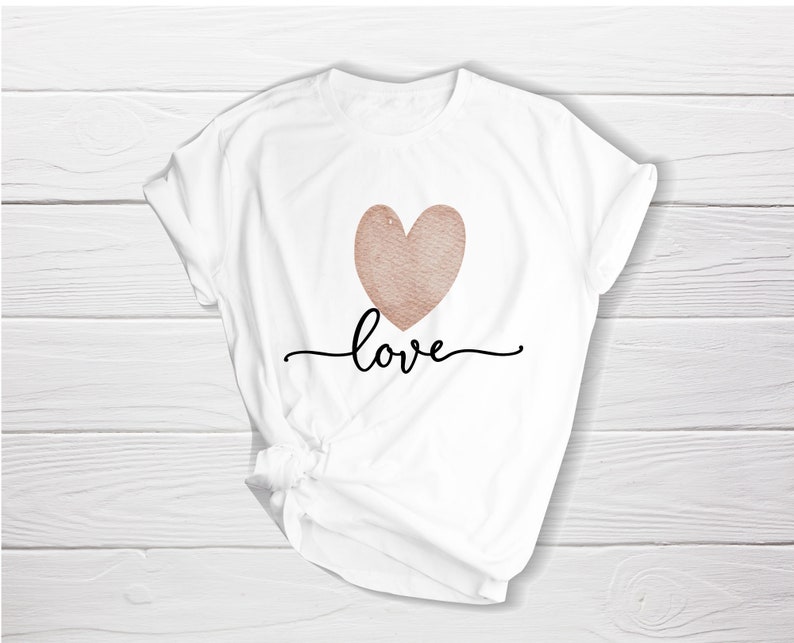 K&ouml;nnte beinhalten: Wei&szlig;es T-Shirt mit einem ros&eacute;goldenen Herzen und dem Wort "love" in schwarzer Schrift.