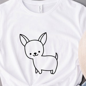 May include: White t-shirt with a black line drawing of a chihuahua on the front.