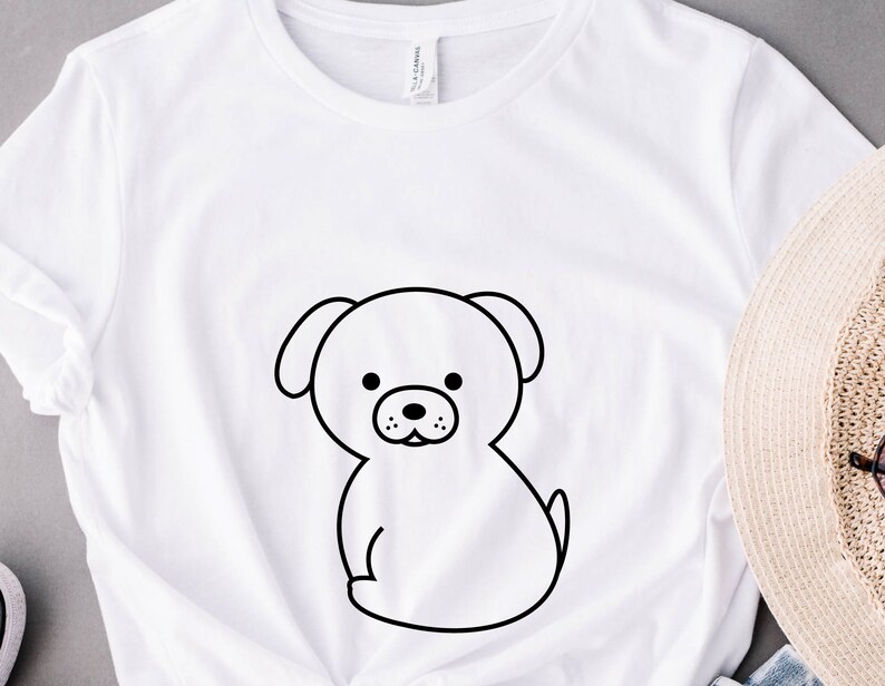 May include: White t-shirt with a black line drawing of a cartoon dog on the front.