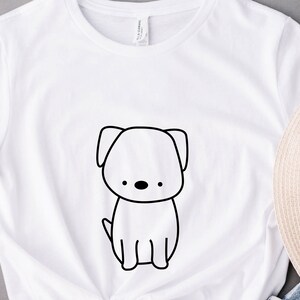May include: White t-shirt with a black line drawing of a dog on the front.