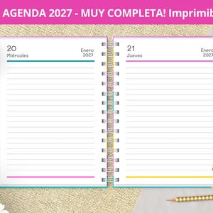 May include: A spiral-bound 2027 daily planner open to January 20th and 21st. The pages feature horizontal lines, colorful accents, and the text "AGENDA 2027 - MUY COMPLETA! Imprimible" at the top. The planner is displayed with a colorful pencil.