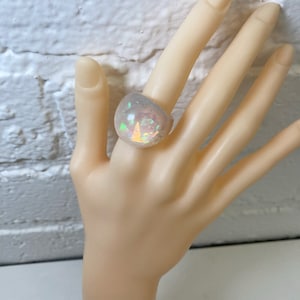 May include: A large, white, iridescent ring with a rounded, domed shape.