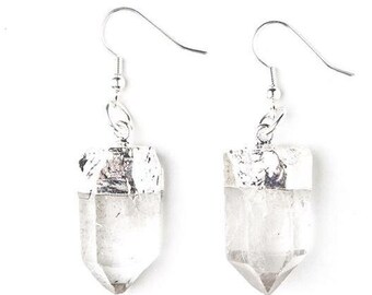 Puede incluir: Un par de pendientes de plata con puntas de cristal de cuarzo transparente. Las puntas de cristal están rematadas con plata.