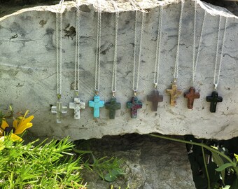 May include: Ten silver necklaces with different colored stone cross pendants. The stones are turquoise, green, red, brown, black, and white.
