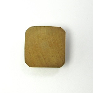 Może przedstawiać: Kwadratowy, drewniany przedmiot z zaokrąglonymi rogami. Drewno ma jasnobrązowy kolor i widoczny wzór słojów. Przedmiot wydaje się być małym, solidnym blokiem, prawdopodobnie do rękodzieła lub użytku dekoracyjnego. Mierzy około 5 cm x 5 cm.